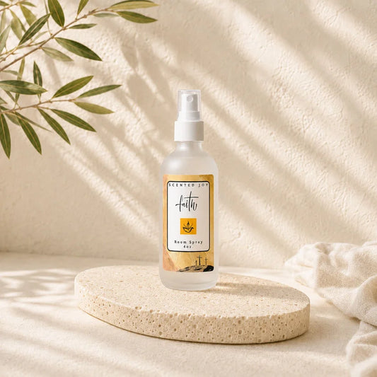 Faith Scented Joy room spray bottle on a stone pedestal with soft leaf shadows.