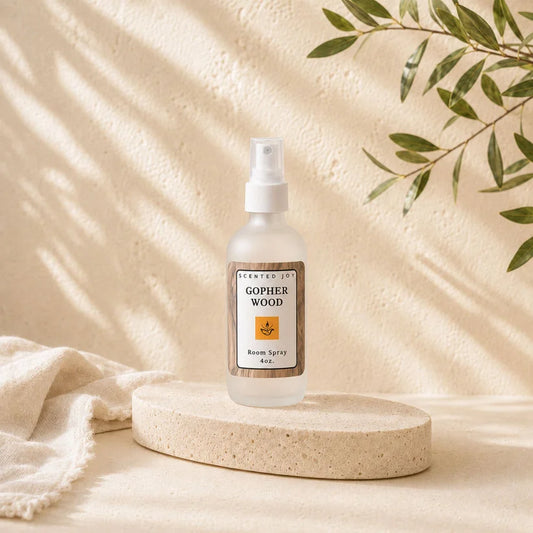 Scented Joy Gopher Wood Room Spray bottle on stone pedestal with natural shadows.