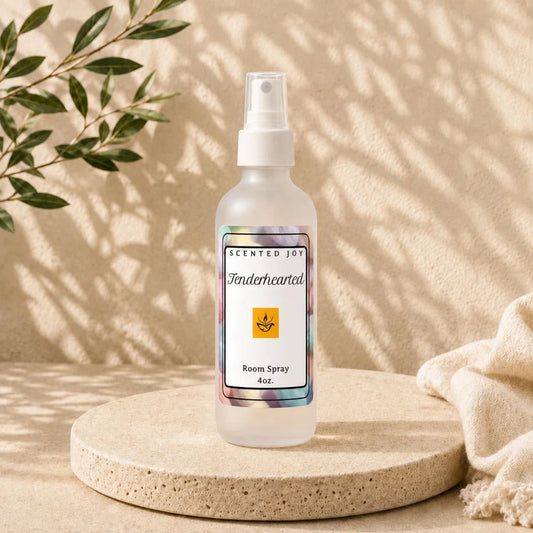 Scented Joy Tenderhearted 4oz room spray on a stone pedestal with leaf shadows.